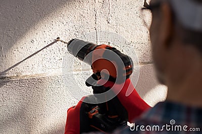 Man drilling hole in wall Stock Photo